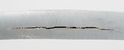 Narrow steel band through which a long crack runs lengthwise.